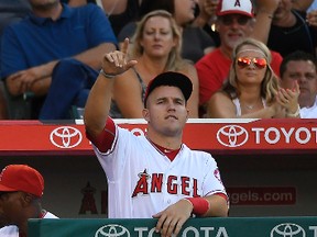 Angels' Mike Trout gestures from the dugout toward first base after C.J. Cron hit an RBI single during the eighth inning of a game against the Reds in Anaheim, Calif., on Wednesday, Aug. 31, 2016. (Mark J. Terrill/AP Photo)