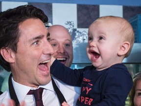 Justin Trudeau makes a funny face with a young child during a campaign stop in Welland, Ont., in this Oct. 14, 2015 file photo. (THE CANADIAN PRESS/Paul Chiasson)