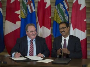 From left, Brian Mason, Alberta Minister of Infrastructure and Transportation and Amarjeet Sohi, Federal Minister of Infrastructure and Communities sign the agreement. September 1, 2016. SHAUGHN BUTTS