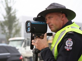 Const. Scott Sellsted, a traffic enforcement officer with the Edmonton Police Service's Southwest Division, looks through a radar gun outside of St. John XXIII Catholic Elementary/Junior High School at 365 Windermere Road on Thursday, Sept. 1, 2016. Edmonton police are urging drivers to stay alert and obey speed limits in school zones. CLAIRE THEOBALD / Postmedia