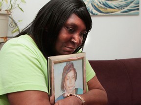 In this Wednesday, Aug. 31, 2016, photo, Theresa Matthews, of Dixmoor, Ill., holds a framed photo of her daughter, Cateresa Matthews, who was kidnapped and murdered in 1991. Prosecutors said Willie Randolph will be charged Thursday, Sept. 1, 2016, with murder and kidnapping in the suburban Chicago girl's death. More than two years ago, five men reached a settlement with Illinois State Police after they were cleared of all charges in the death of Matthews. The men, known as the "Dixmoor Five," spent a decade or more in prison before DNA evidence pointed to Randolph. (Leslie Adkins/Chicago Sun-Times via AP)