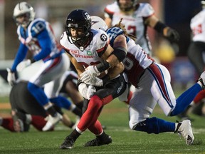 Montreal Alouettes linebacker Bear Woods (right) tackles Redblacks receiver Brad Sinopoli during the first half at Molson Stadium. (The Canadian Press)