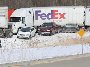 A worker surveys some of the wreckage in Highway 402 after a 30-vehicle pileup back in February 2014. File photo.