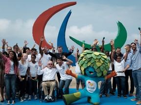 Philip Craven (on a wheelchair), President of the International Paralympic Committee and students of the Benjamin Constant Institute for blind or visually impaired people, during the inauguration of the symbol of the Rio 2016 Paralympic Games at Copacabana Beach in Rio de Janeiro, Brazil, on September 2, 2016. The sculpture is made out of recycled materials collected at the beach and offers different textures and smells for the interaction with people. (YASUYOSHI CHIBA/AFP/Getty Images)