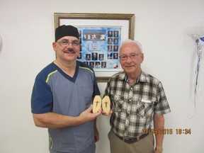 Alain Levesque, left, head chef at the La Rive de Grande-Riviere seniors residence, and president of the residence Emilien Morin pose for Sept. 1, 2016, handout photo with a potato residents at the home believe has a divine message. Levesque was slicing potatoes Aug. 22 when he accidentally - some might say miraculously - made a perfect lengthwise cut, revealing what he would later describe as a sign of the cross in the centre of each half. THE CANADIAN PRESS/HO-Gaston Lebreux