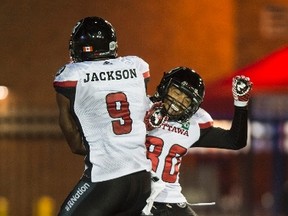 Redblacks receiver Ernest Jackson celebrates his touchdown against the Alouettes with Chris Williams. (The Canadian Press)