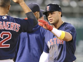 Yoan Moncada is greeted by Boston teammates after scoring a run in his Red Sox debut on Friday night in Oakland. (AP)