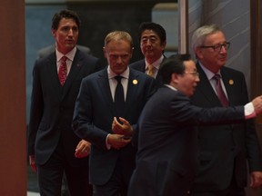Canadian Prime Minister Justin Trudeau (left), follows European Council President Donald Tusk, Japanese Prime Minister Shinzo Abe and European Commission President Jean-Claude Juncker (right) to the leaders photo  at the G20 Leaders Summit in Hangzhou, Sunday September 4, 2016. THE CANADIAN PRESS/Adrian Wyld
