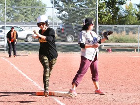 Candace Gillanders, from Blackie, AB, runs to first base while Lindsay Mullins, from Strathmore, AB, watches for the ball with one foot on the base during the Mossleigh slowpitch tournament Saturday.