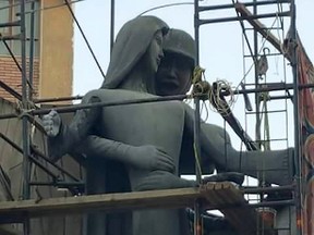 A sculpture, titled “Mother of the Martyr,” depicts a slender peasant woman, a traditional artistic representation of Egypt, with her arms outstretched with a helmeted soldier standing behind her, at a public square in Sohag, Egypt. A provincial governor in Egypt has ordered changes to a sculpture honoring fallen soldiers after many on social media said it appeared to depict an unwanted advance on a woman symbolizing the country. (AP Photo/Mahmoud Ahmed)