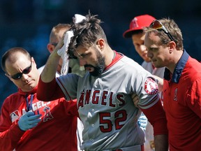 Angels starting pitcher Matt Shoemaker is assisted off the field after being hit by a line drive from Mariners' Kyle Seager in the second inning in Seattle on Sunday, Sept. 4, 2016. (Elaine Thompson/AP Photo)