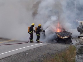 Firefighters try to extinguish a car on fire near Wawa, Ont., Monday, Sept.5, 2016. Police say four people have died in a collision in northern Ontario near Wawa on Monday morning. They say it happened when a vehicle crashed into a rock cut at about 7:30 a.m. THE CANADIAN PRESS/Brenda Grundt
