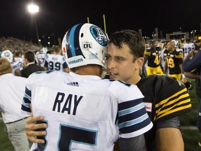 Quarterbacks Ricky Ray (left) and Zach Collaros (right) hug following the Labour Day Classic in Hamilton, Ont., on Monday, Sept. 5, 2016. (Peter Power/The Canadian Press)