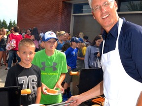 The new Grade 7 MDHS students were given a warm welcome to their new high school Aug. 30 with a tour of the school ending in a barbecue lunch. Pictured, new MDHS vice principal Ian Moore serves up a freshly grilled burger to Josh Martyn. GALEN SIMMONS MITCHELL ADVOCATE