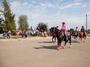 Wild Pink Yonder, a charitable society that runs a 23 day, 500-kilometre trail ride as a fundraiser for breast cancer research, ride through the main street of Innisfree Alta., on Wednesday, August 31, 2016. Taylor Hermiston/Vermilion Standard/Postmedia Network.