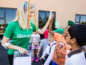 Grade one teacher, Jaime Moss, hi-fives her students at the brand new Kanata Highlands Public School after recess on the first day of school Tuesday. Darren Brown/Postmedia