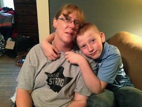 In this Aug. 30, 2016 photo, Becky Carter Phillips and her son Carter Phillips, look at a remembrance wall at their home in White Sulphur Springs, W.Va. The wall is in honor of Mykala Phillips, who was swept away by floodwaters on June 23, 2016. Her body was found weeks later. (AP Photo/John Raby)