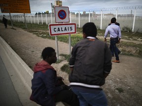 Migrants walk past security fencing at the Jungle migrant camp on Sept. 6, 2016, in Calais, France. (Christopher Furlong/Getty Images)