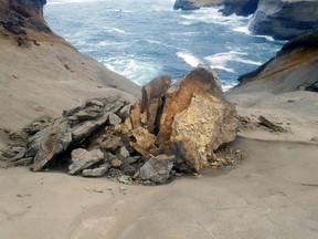 This undated photo provided by State of Oregon, Oregon Parks and Recreation Department shows a natural rock formation that was found in pieces last week at Cape Kiwanda State Natural Area which is a state park in Pacific City, Ore. The sandstone pedestal was roughly 7 feet to 10 feet across and located in a fenced off section of the park. Oregon State Parks officials originally said they did not think the break at the site frequented by tourists was caused by humans but cellphone video captured a group of people knocking over the popular sandstone rock formation known as the "Duckbill" on the Oregon beach. (State of Oregon, Oregon Parks and Recreation Department via AP)