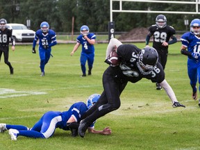 Etienne de Jongh of the Cats football team tries to pull away from a Titans player on Sept. 9. Hannah Lawson | Whitecourt Star