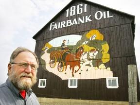 Charlie Fairbank, in a file photo, stands in front of his barn painted with a mural depicting the beginning of Fairbank Oil. He plans to seek a world heritage site designation for his family's Oil Springs properties and the county-operated Oil Museum of Canada, through the United Nations Educational, Scientific and Cultural Organization (UNESCO). (Ken Wightman/ Postmedia Network)