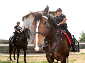 Kingston Police Const. Deb Wicklam sits on Murney, who was officially named by Kingston Police on Wednesday at Murney Tower. Also at the event was Const. Sarah Groenewegen with Donovan. (Ian MacAlpine/The Whig-Standard)