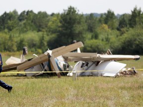 A Carroll County Fire official walks past the debris of a plane crash at West Georgia Regional Airport in Carrollton, Ga., Wednesday, Sept. 7, 2016. Carroll County Fire Chief Scott Blue says two single-engine planes may have been trying to land at the same time when they collided at the small airport in western Georgia leaving three people dead. (AP Photo/David Goldman)