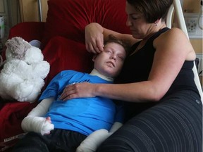 Jonathan Pitre is comforted by his mother, Tina Boileau, following a draining round of radiation Wednesday at the University of Minnesota Masonic Children's Hospital on the event of becoming the first Canadian to undergo an EB bone marrow transplant. Julie Oliver/Postmedia