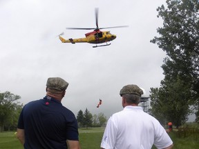 Ernst Kuglin/Intelligencer File Photo
8 Wing/CFB Trenton CWO Darcy Elder, and Col. Colin Keiver watch as 424 “Tiger” Squadron Sar Tech. WO Aaron Bygrove rappels from a helicopter prior to the start of this year's Wing Commander’s Golf Tourney at Roundel Golf Course. The tourney was the launch of the Wing’s Workplace Charitable Campaign (GCWCC) which closed this week raising $124,648.