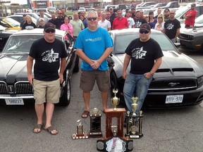 David Gough/Courier Press/DGough@postmedia.com
The third annual Glen Jackson Memorial Raceday is scheduled for Sept. 10 at Grand Bend Raceway. Jackson, who died in 2013, was passionate about cars. The event will honour his memory, as well as raise funds for the Wallaceburg Splash Pad project. Pictured are his sons Kyle and Jason, front, as well as Splash Pad fundraising chairperson Chris Young, front middle.