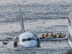 In this Jan. 15, 2009 file photo, passengers in an inflatable raft move away from an Airbus 320 US Airways aircraft that has gone down in the Hudson River in New York. Accident investigators say they object to their portrayal in a new movie based on the “Miracle on the Hudson” river ditching of airliner seven years ago after striking geese. (AP Photo/Bebeto Matthews, File)