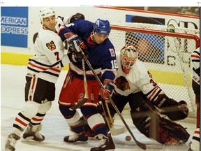 Chicago Blackhawks' defenseman Chris Chelios (left) keeps Winnipeg Jets' Eddie Olczyk (right) from getting his stick on the puck in front of Chicago goalie Jeff Hackett in the first period of an NHL game in 1995. Olcyzk has been named to the Jets' alumni roster for its game next month at Investors Group Field. (FILE PHOTO)