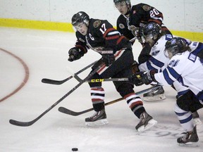 Hunter Tyczynski of the Sarnia Legionnaires shakes off two London Nationals during a Greater Ontario Junior Hockey League last season. Sarnia Observer file photo)
