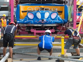 A trio of workers position a section of track containing the Crazy Mouse Coaster cars as it is lowered into place at the Western Fair in London, Ont. on Thursday September 8, 2016. The Fair runs September 9 to 18. (CRAIG GLOVER, The London Free Press)