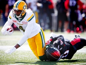 Edmonton Eskimos Adarius Bowman is tackled by Ciante Evans of the Calgary Stampeders during CFL football in Calgary, Alta., on Monday, September 5, 2016.