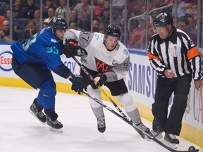 Team North America's Connor McDavid (right) skates to the puck behind the net as Team Europe's Zdeno Chara (left) chases him during the first period of a pre-tournament game at the World Cup of Hockey in Quebec City on Thursday, Sept. 8, 2016. (Jacques Boissinot/The Canadian Press)