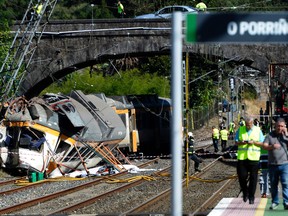 Firefighters and rescuers inspect the wreckage of a train derailed in Porrino, northwestern Spain, leaving at least four people dead and dozens injured, on Sept. 9, 2016. (MIGUEL RIOPA/AFP/Getty Images)