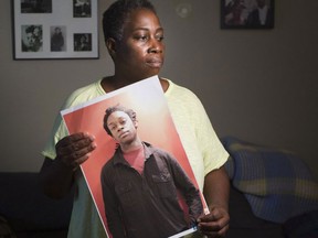 Maureen Henry holds a photograph of her son, Dovi, who was found dead and without ID in Lake Ontario near Ontario Place in July 2014, in her house in Ottawa Wednesday, Sept. 7, 2016. (Darren Brown/Postmedia)
