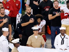 FILE - In this Thursday, Sept. 1, 2016, file photo, San Francisco 49ers quarterback Colin Kaepernick, center, kneels during the national anthem before an NFL preseason football game against the San Diego Chargers in San Diego. With Case Keenum and Blaine Gabbert set as starting quarterbacks, Kaepernick's refusal to stand for the anthem getting more public acceptance and the Rams mostly settled into their new home, much of the focus when the teams open the season on Monday night will be on the running backs. (AP Photo/Chris Carlson, File)
