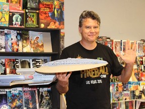 Trent Rogers flashes the Vulcan salute while holding a model of the Starship Enterprise at Future Pastimes Friday. A diehard Trekkie, Rogers estimates he owns more than 200 Star Trek books and more than 300 comics from the popular science fiction franchise. (Barbara Simpson/Sarnia Observer)