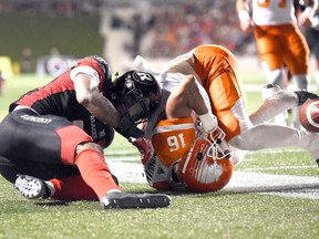 The ball bounces out of the reach of B.C. Lions’ Bryan Burnham (16) after a collision with Ottawa Redblacks’ Jermaine Robinson (2) Thursday, Aug. 25, 2016 in Ottawa. (THE CANADIAN PRESS/Justin Tang)