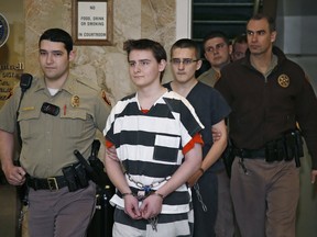 FILE- In this Tuesday, Feb. 23, 2016 file photo, Robert Bever, second from left, and Michael Bever, third from left, are escorted into a courtroom for a hearing in Tulsa, Okla. The two Oklahoma teenage brothers are charged with fatally stabbing their parents and three of their younger siblings. Robert Bever, the elder of the two, has been sentenced to life without parole after pleading guilty in the killings. (AP Photo/Sue Ogrocki, File)