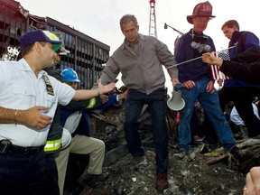 FILE - In this Friday, Sept. 14, 2001 file photo, Joseph Esposito, left, chief of department of the New York Police Department, offers help as President George W. Bush steps off of a pile of rubble after speaking at ground zero of the World Trade Center site in New York. Esposito, then the NYPD's top uniformed officer, was struck by "the camaraderie, the unity" of those days. (AP Photo/Doug Mills)