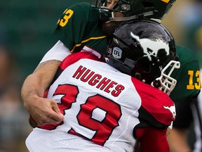 Edmonton Eskimos quarterback Mike Reilly (13) gets hit by Calgary Stampeders Charleston Hughes (39) on Saturday, September 10, 2016 in Edmonton.