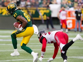 Calgary Stampeders Tommie Campbell (25) tries to stop Edmonton Eskimos Derel Walker (87) as he makes the interception for a touchdown during first half CFL action in Edmonton, Alta., on Saturday September 10, 2016.