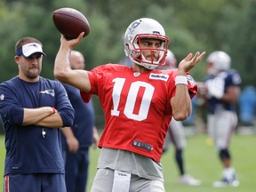 New England Patriots' Jimmy Garoppolo (10) winds up for a pass as offensive coordinator Josh McDaniels, left, looks on during an NFL football practice, Wednesday, Sept. 7, 2016, in Foxborough, Mass. (AP Photo/Steven Senne)