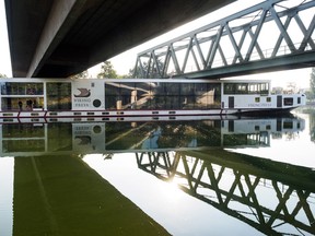 A river cruise ship sticks underneath a railway bridge on the Main-Danube Canal near Erlangen, Germany, Sunday Sept. 11, 2016. Authorities say the river cruise ship hit a rail bridge in southern Germany, crushing the wheelhouse and leaving two crew members dead. The ship had just cast off early Sunday from the town of Erlangen on its way to the Hungarian capital, Budapest, along the Main-Danube Canal when the accident occurred, the news agency dpa reported. The dead were a 49-year-old who was at the wheel of the vessel and a 33-year-old sailor. (Nicolas Armer/dpa via AP)