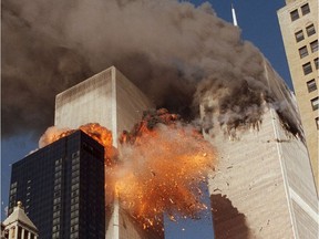 In this Sept. 11, 2001 file photo, smoke billows from World Trade Center Tower 1 and flames explode from Tower 2 as it is struck by American Airlines Flight 175, in New York.