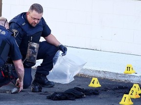 Constable Ryan McMahon a Forensic Identification Specialist with the Greater Sudbury Police Service collects evidence where a incendiary device was found behind the Montrose Mall  in Sudbury, Ont. on Sunday September 11, 2016. Gino Donato/Sudbury Star/Postmedia Network