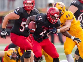 Queen’s Golden Gaels linebacker Mike Moore tries to tackle Gryphons running back Daniel Palmer-Salmon during an Ontario University Athletics football game in Guelph on Saturday. (Ontario University Athletics)